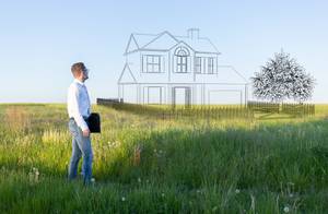 Man stands on a meadow and imagines his dream house.