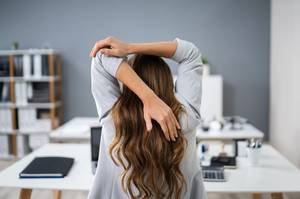 person stretches at desk