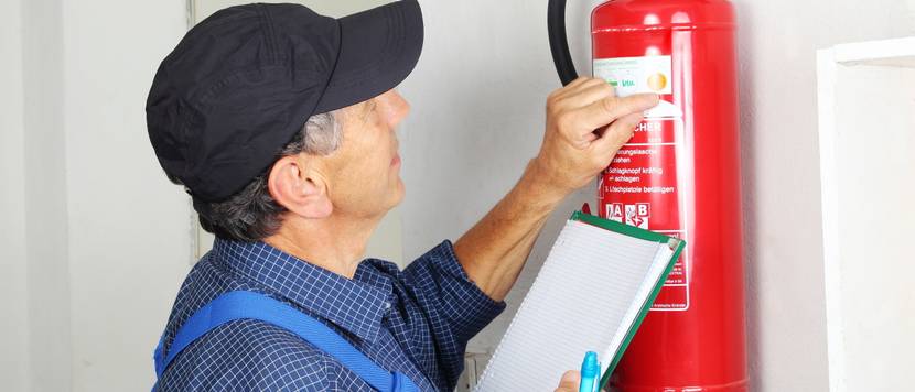 man sticks inspection sticker on fire extinguisher